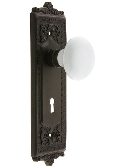 Egg and Dart Style Mortise Lock Set with White Porcelain Door Knobs in Oil-Rubbed Bronze.